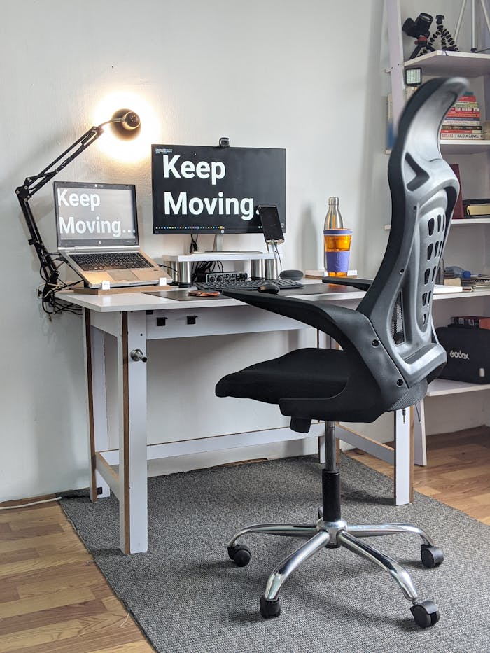home-img Stylish home office with ergonomic chair, desk, laptop, and motivational screens.